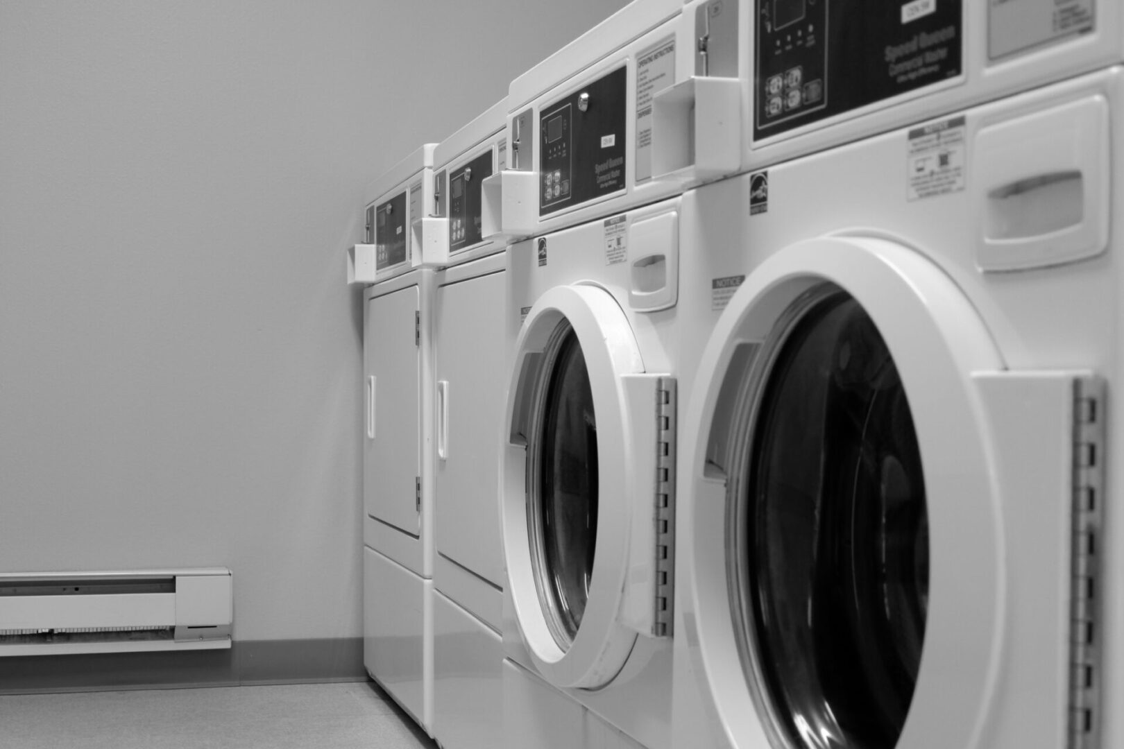 A row of white washing machines in a room.