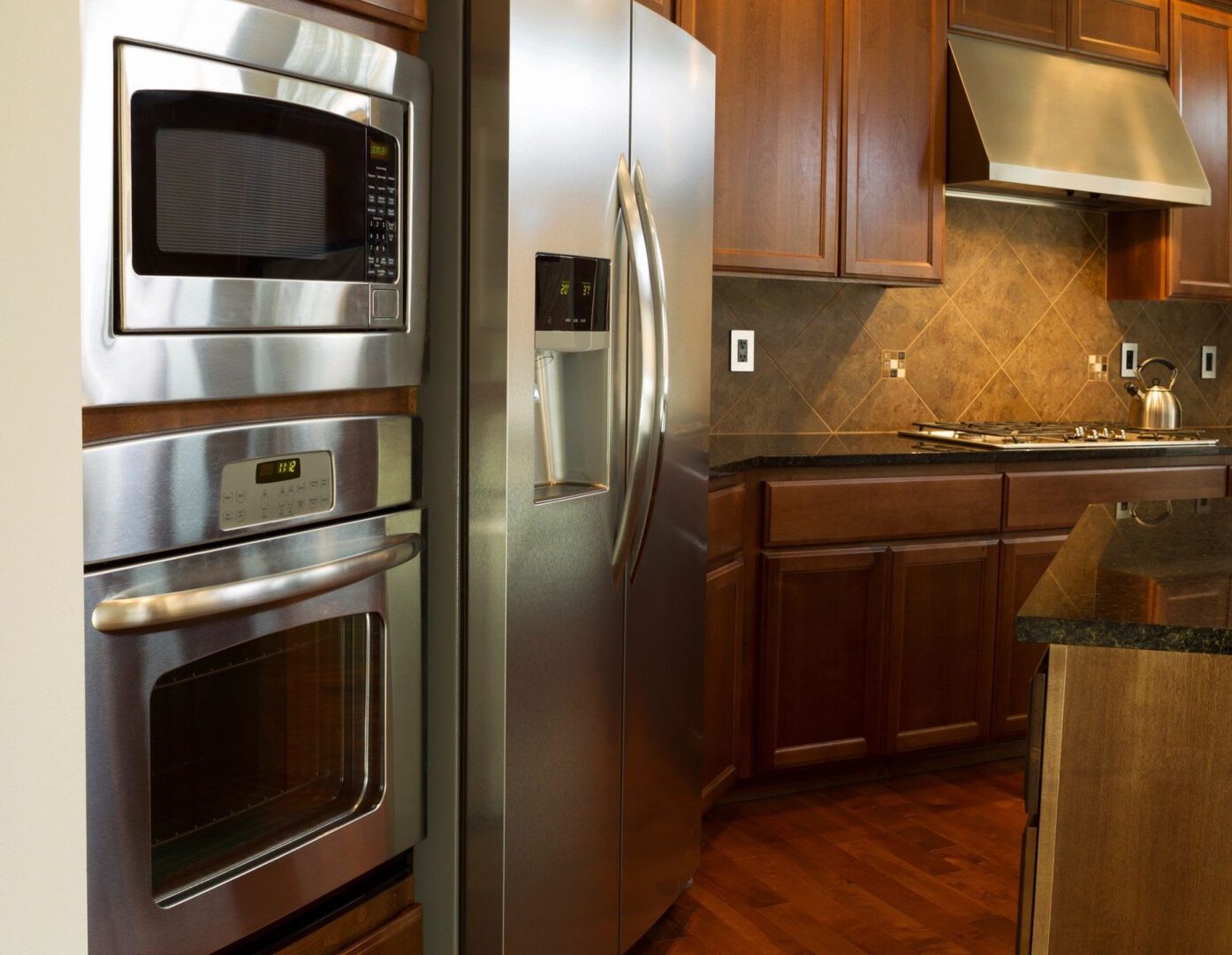 A kitchen with stainless steel appliances and wooden cabinets.