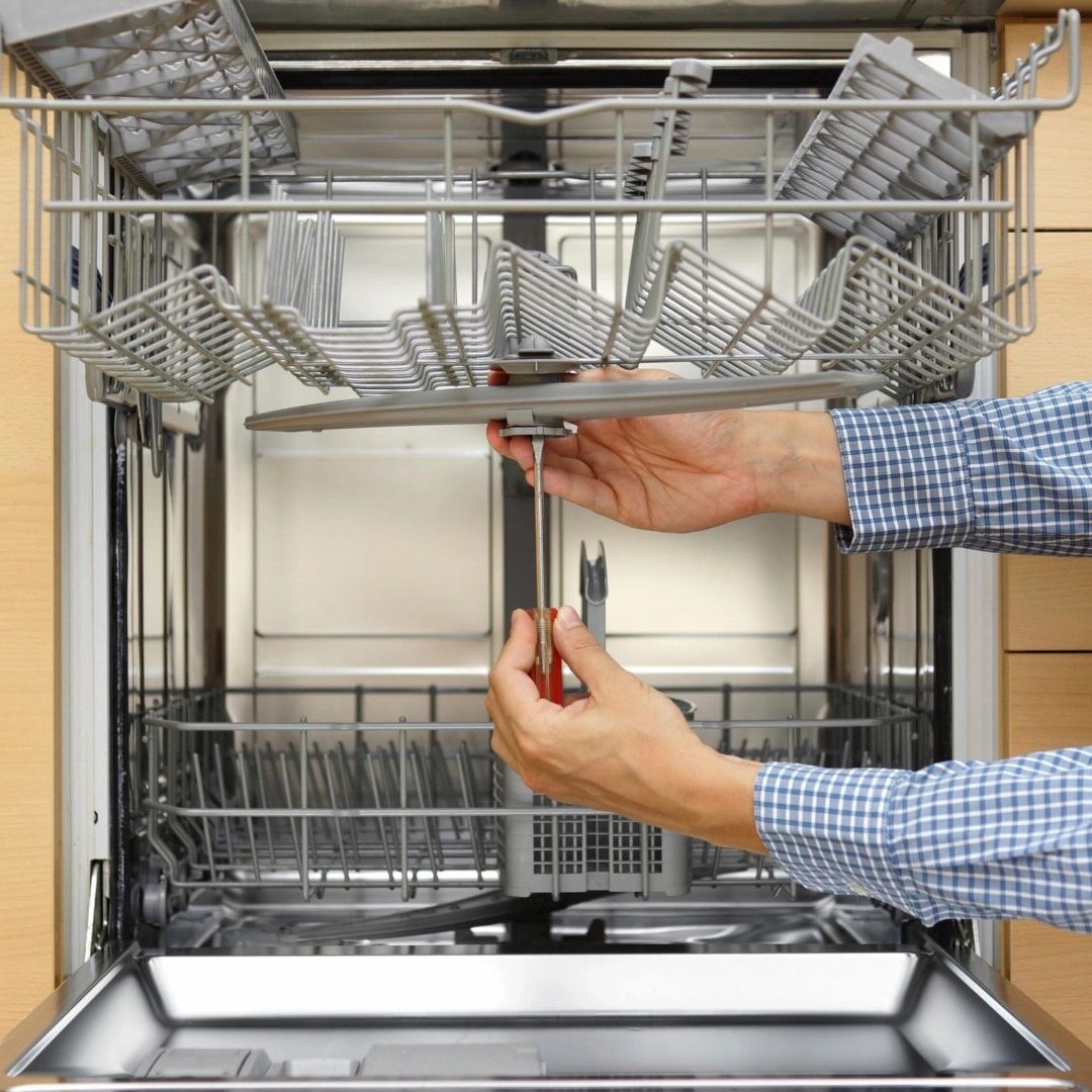 A person is loading the dishwasher with their hands.